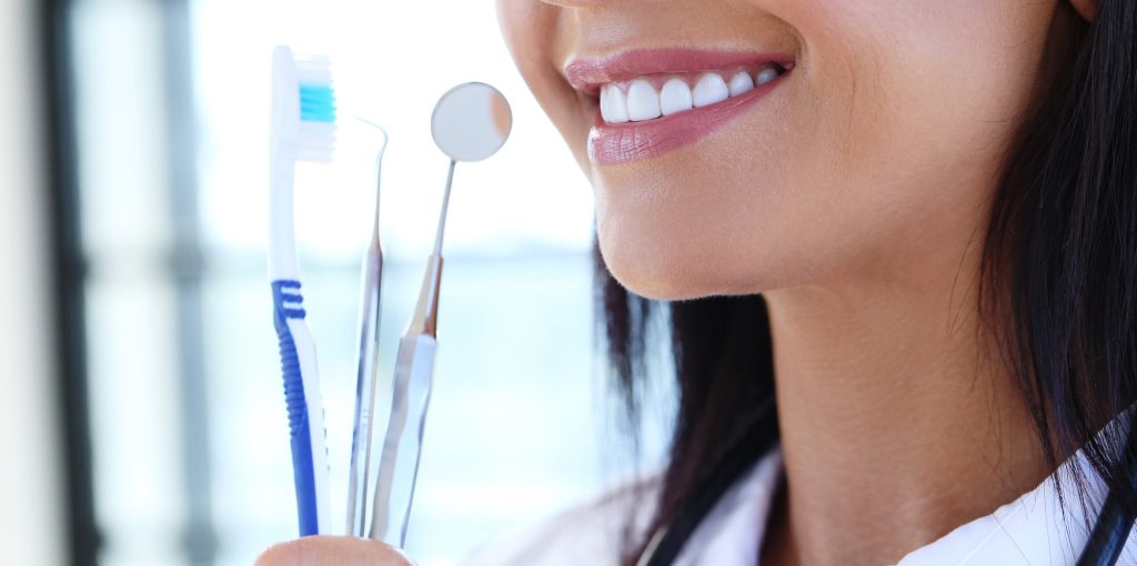 Image d'une femme qui garde ses dents propres grâce aux des soins dentaires.

