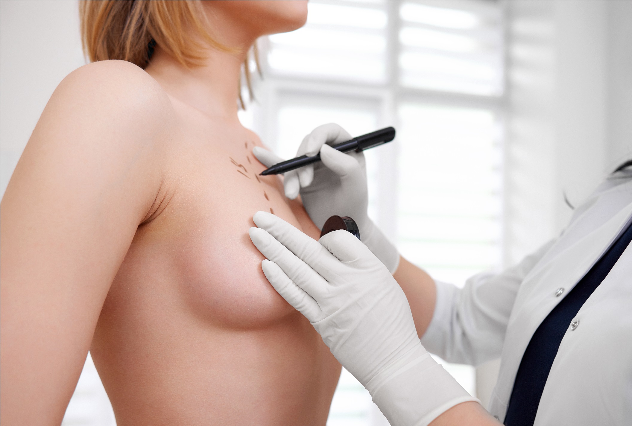 a young woman visiting a doctor preparing for breast augmentation surgery